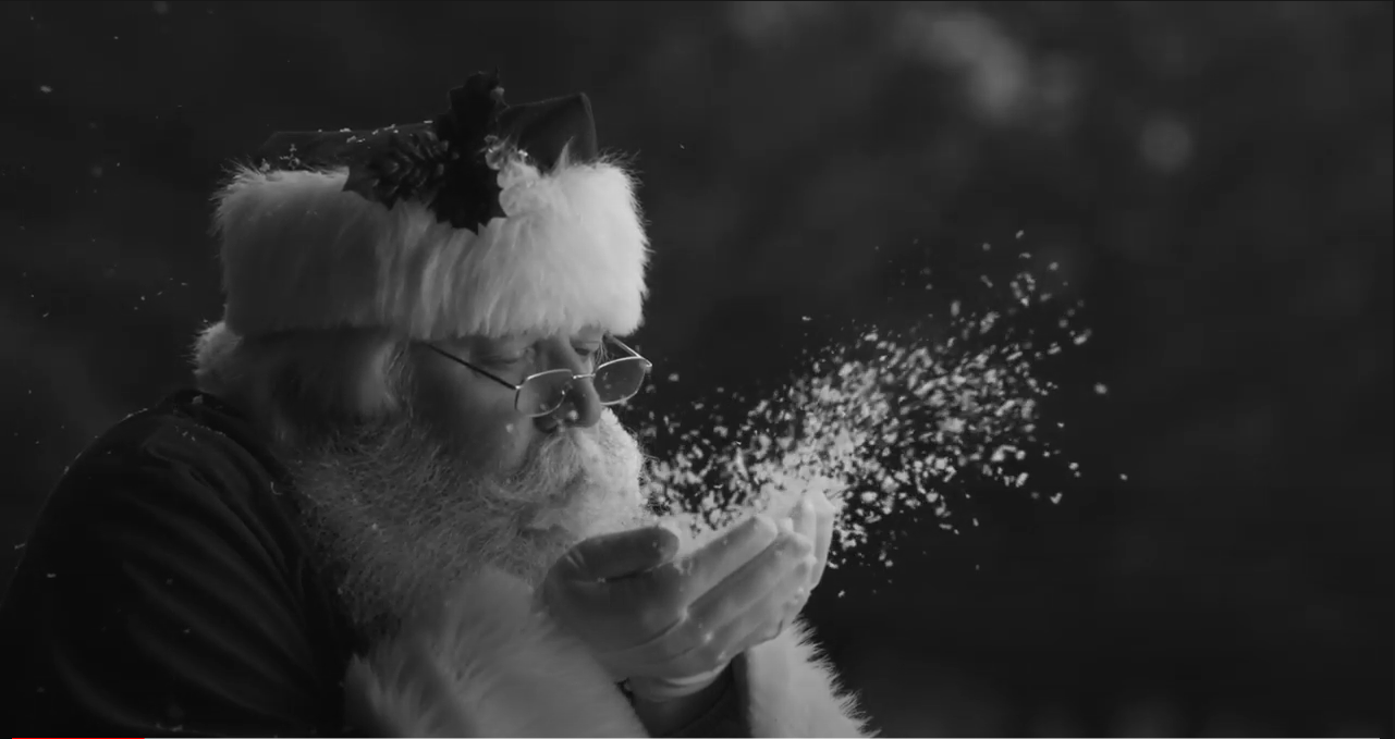 Santa blowing snowflakes out of his hand.